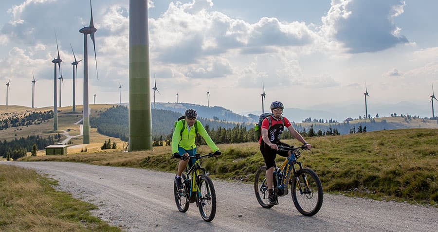 zwei-maenner-fahren-mit-dem-e-bike-durch-den-windpark-pretul-in-muerzzuschlag
